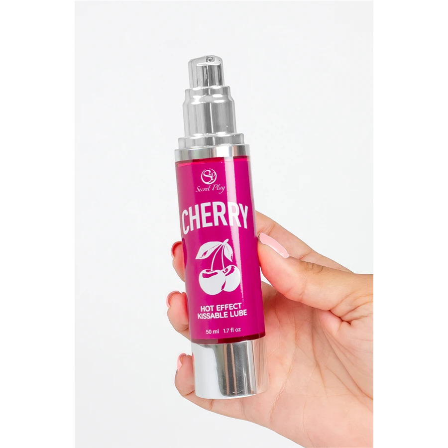 Lubrifiant Secret Play cerise tenu en main, flacon pompe 50 ml sur fond blanc, échelle du produit